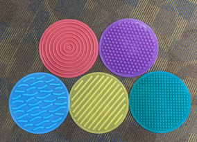 five circular sensory toys with different textures